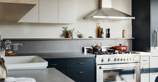 White, blue, and gray kitchen featuring concrete countertops.