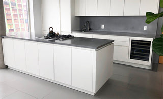 White and gray kitchen with dark gray concrete countertops and backspalsh.
