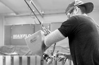 Truform Concrete team member operating specialized mixing and spraying equipment in the fabrication facility—showcasing advanced concrete casting techniques for custom architectural and designer products.