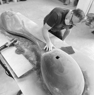 Truform Concrete artisan hand-finishing a sculptural custom concrete sink form in the workshop—highlighting craftsmanship, precision fabrication, and bespoke surface design for architectural and designer projects